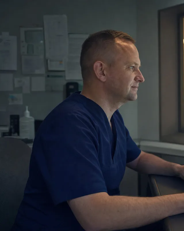 A radiographer at a CT control-room console