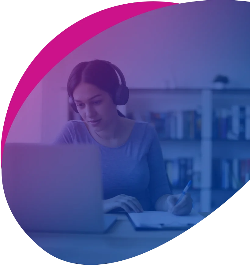 Photo of a woman wearing a headset and working on a laptop