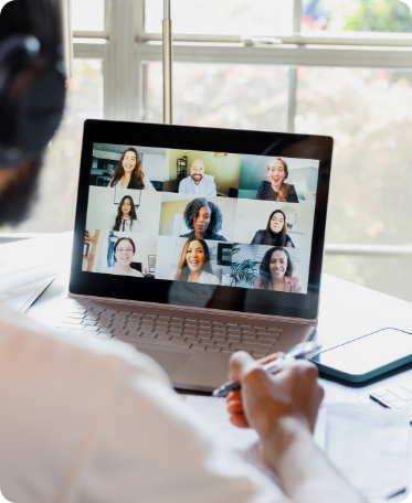 Photo of a laptop whose screen displays a group of people connected to a videoconference